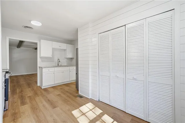 a view of a kitchen with white wooden cabinets and white appliances
