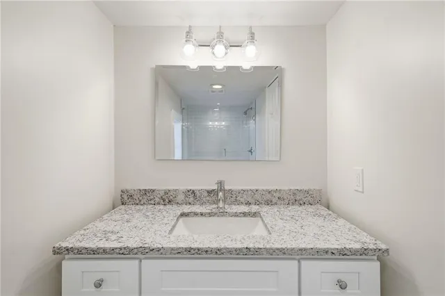 a bathroom with a granite countertop sink and a mirror