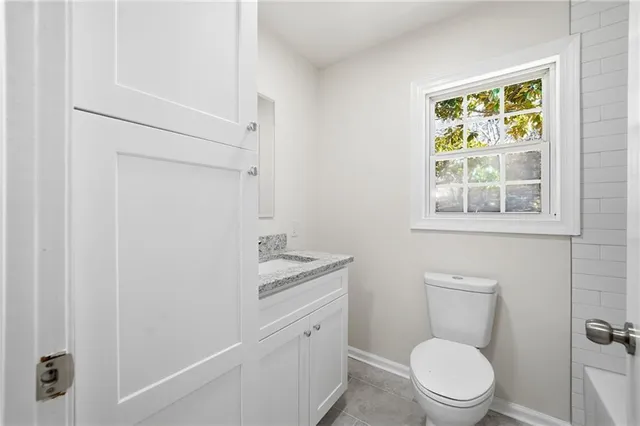 a bathroom with a toilet a sink and a window
