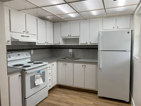 a kitchen with stainless steel appliances granite countertop a refrigerator stove a sink and dishwasher with wooden floor