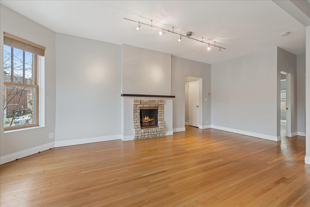 609 West Melrose Street, Unit 2 Chicago, IL 60657 - Photo 4 of 16 wooden floor fireplace and windows in an empty room