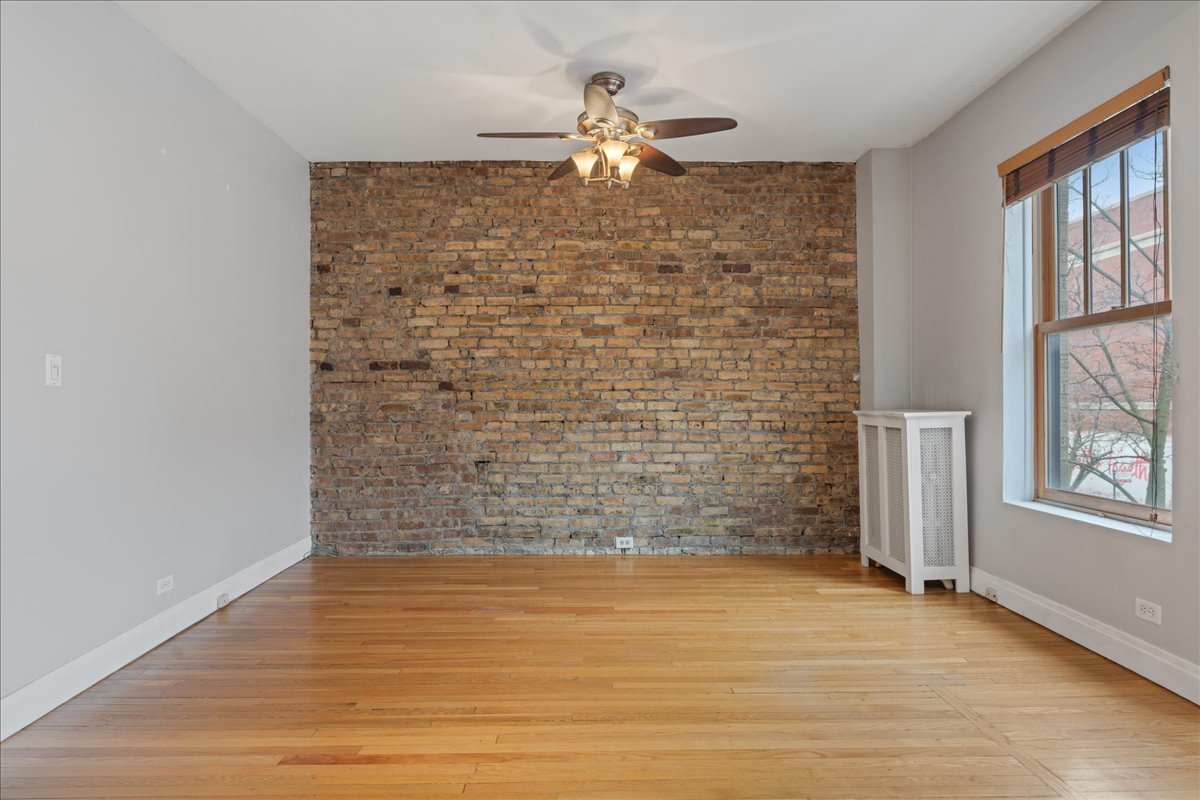 609 West Melrose Street, Unit 2 Chicago, IL 60657 - Photo 6 of 16 wooden floor in an empty room with a window