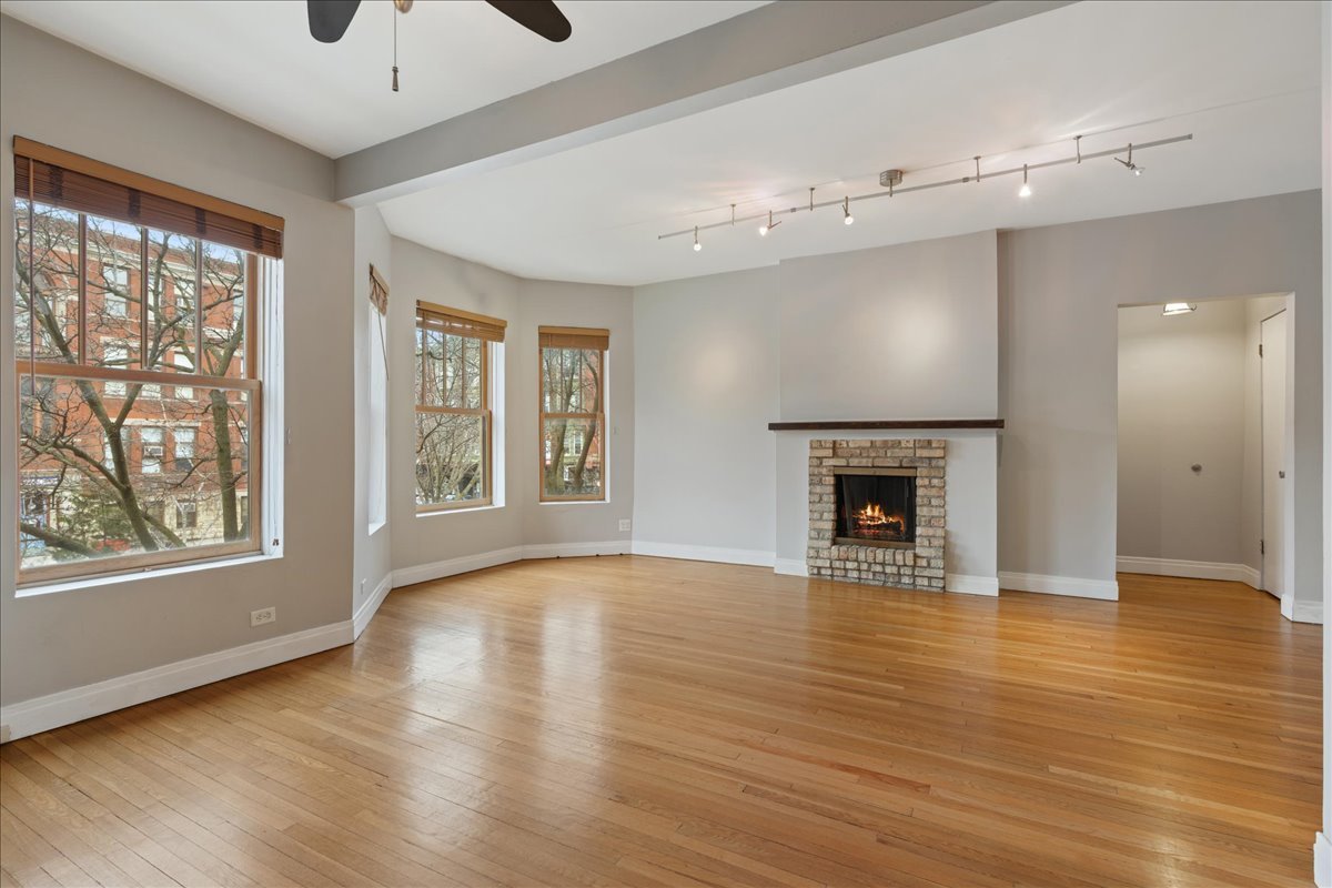 609 West Melrose Street, Unit 2 Chicago, IL 60657 - Photo 7 of 16 a view of an empty room with a window and wooden floor