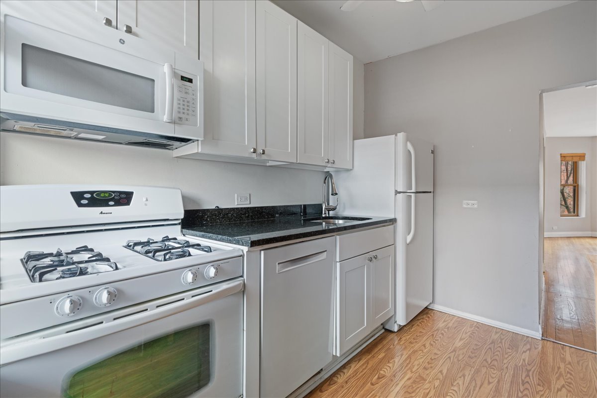 609 West Melrose Street, Unit 2 Chicago, IL 60657 - Photo 9 of 16 a kitchen with stainless steel appliances white cabinets and a stove top oven