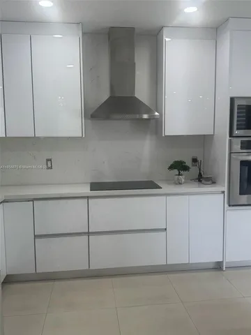 a kitchen with kitchen island a counter top space stainless steel appliances and cabinets