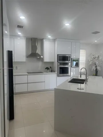 a kitchen with kitchen island cabinets and refrigerator