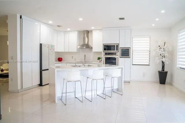 a kitchen with a sink a microwave and cabinets