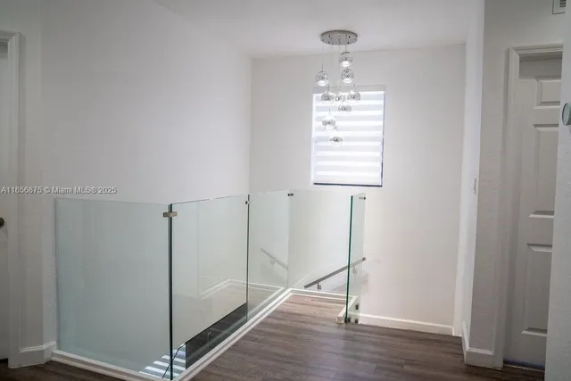 a view of a hallway with wooden floor and closet