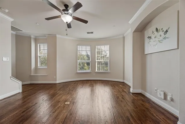 a view of an empty room with window and wooden floor