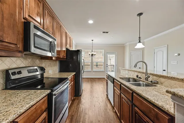 a kitchen with stainless steel appliances granite countertop a sink stove and refrigerator
