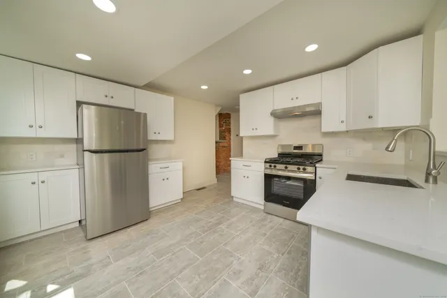a kitchen with cabinets a refrigerator and a stove