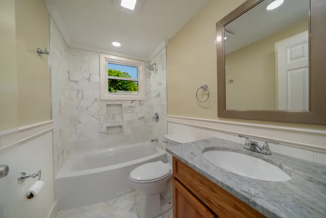 a bathroom with a granite countertop sink toilet and shower