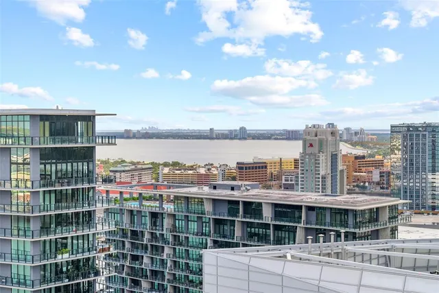 a dining hall with stainless steel appliances kitchen island granite countertop a table chairs and a view of living room