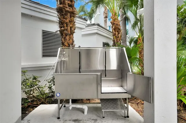 a kitchen with stainless steel appliances granite countertop a stove top oven a sink dishwasher a dining table and chairs with wooden floor