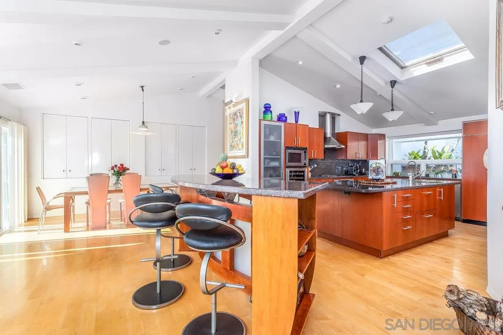 925 Havenhurst Drive La Jolla, CA 92037 - Photo 10 of 17 a kitchen with stainless steel appliances kitchen island granite countertop a table and chairs in it