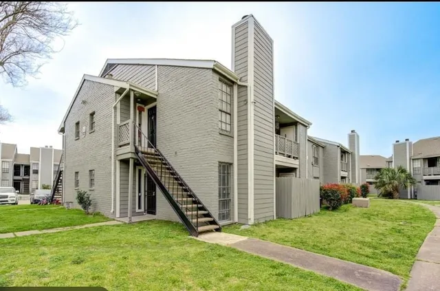 a view of a house with a yard and stairs