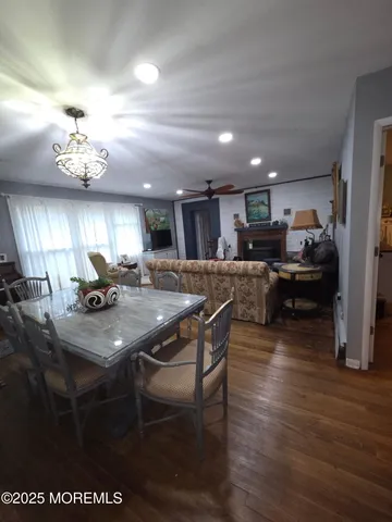 a kitchen with stainless steel appliances granite countertop a stove refrigerator a sink dishwasher a dining table and chairs with wooden floor