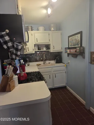 a kitchen with a sink a stove and cabinets