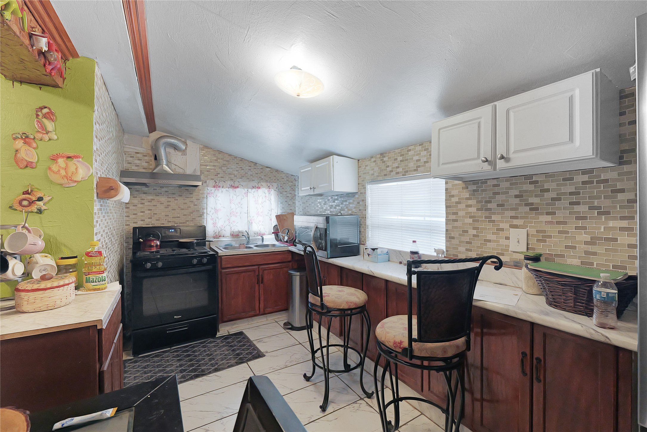 7525 Canal Street Houston, TX 77012 - Photo 7 of 18 a kitchen with stainless steel appliances granite countertop a stove a refrigerator a sink dishwasher and white cabinets with wooden floor