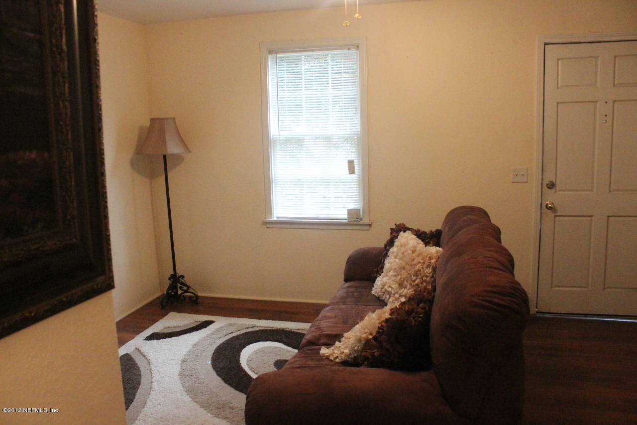 4525 Sunderland Road Jacksonville, FL 32210 - Photo 21 of 35 a bed sitting in a bedroom next to a window