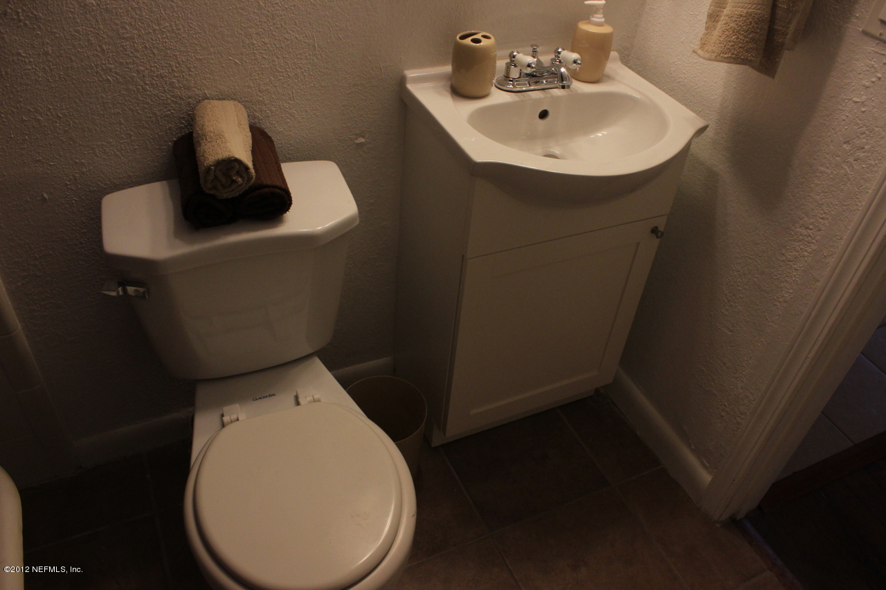 4525 Sunderland Road Jacksonville, FL 32210 - Photo 23 of 35 a bathroom with a toilet sink and mirror