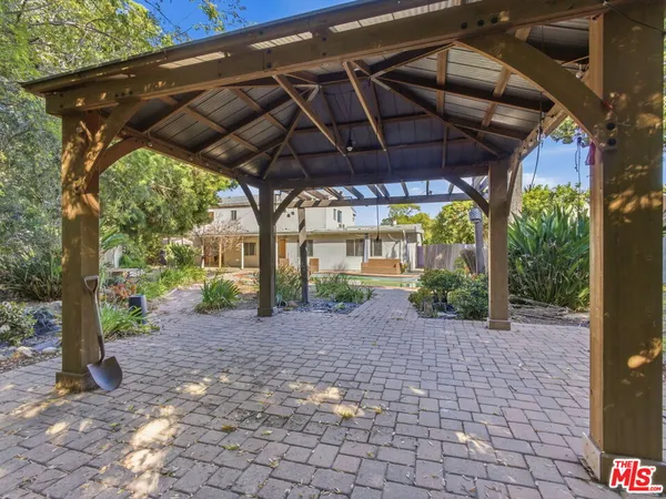 a view of a backyard with table and chairs under an umbrella