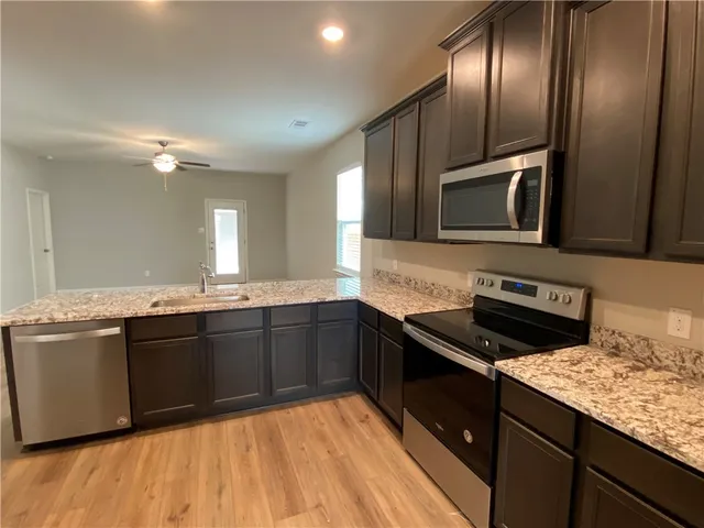 a kitchen with a refrigerator sink and wooden floor