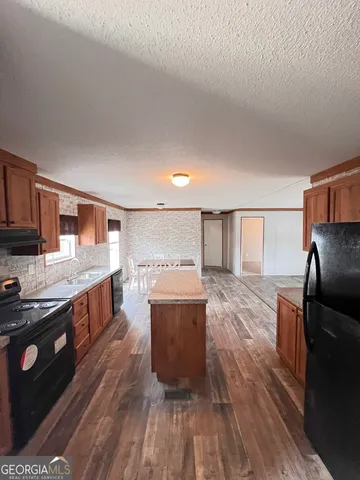 a kitchen with a sink a counter top space stainless steel appliances and cabinets