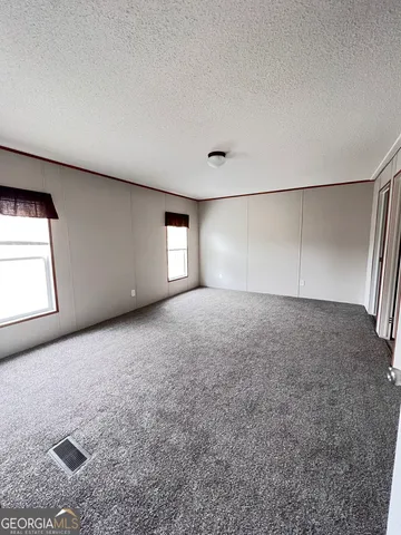 an empty room with windows and closet