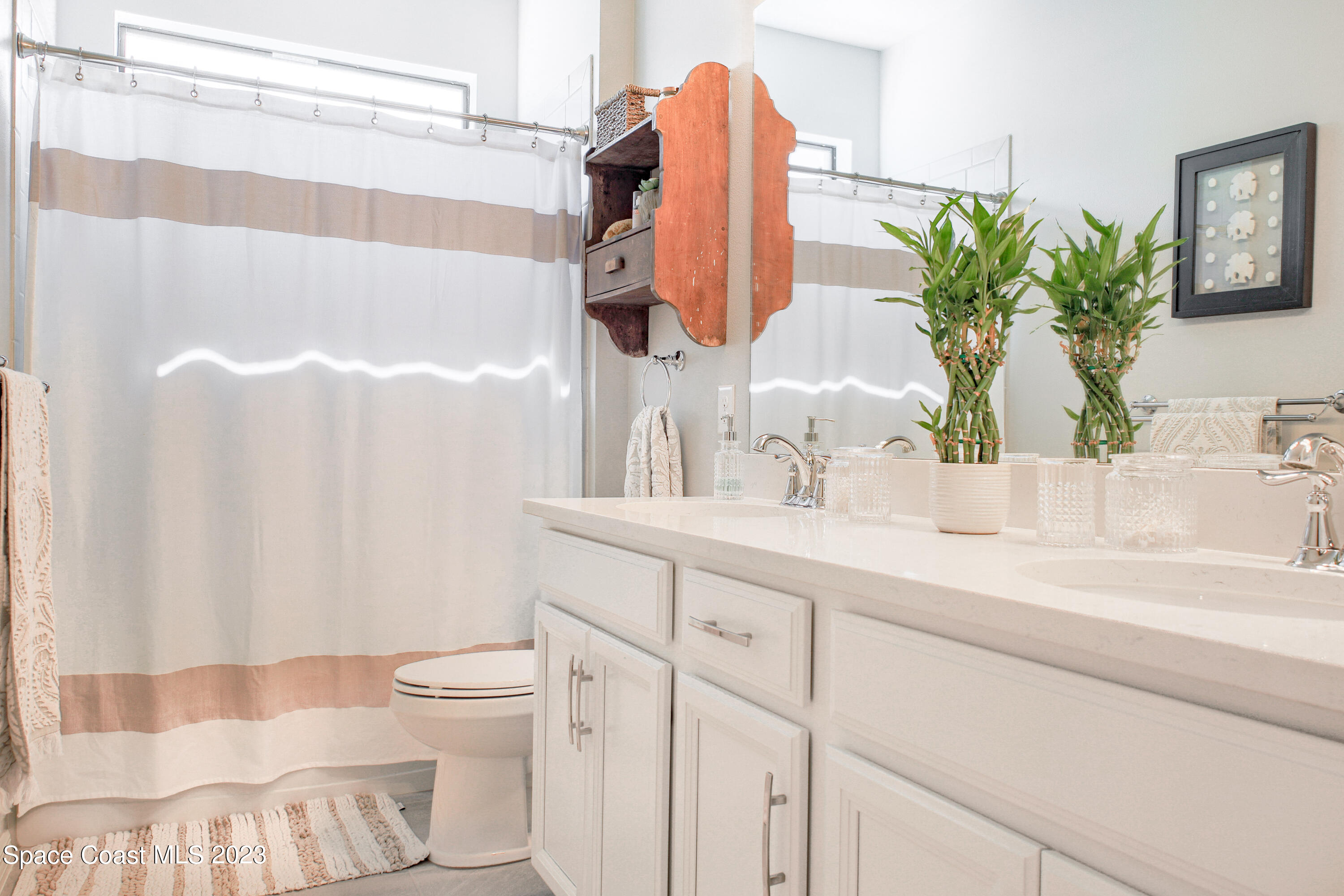 3349 Ribbon Grass Drive Melbourne, FL 32940 - Photo 14 of 45 a bathroom with a sink and a mirror