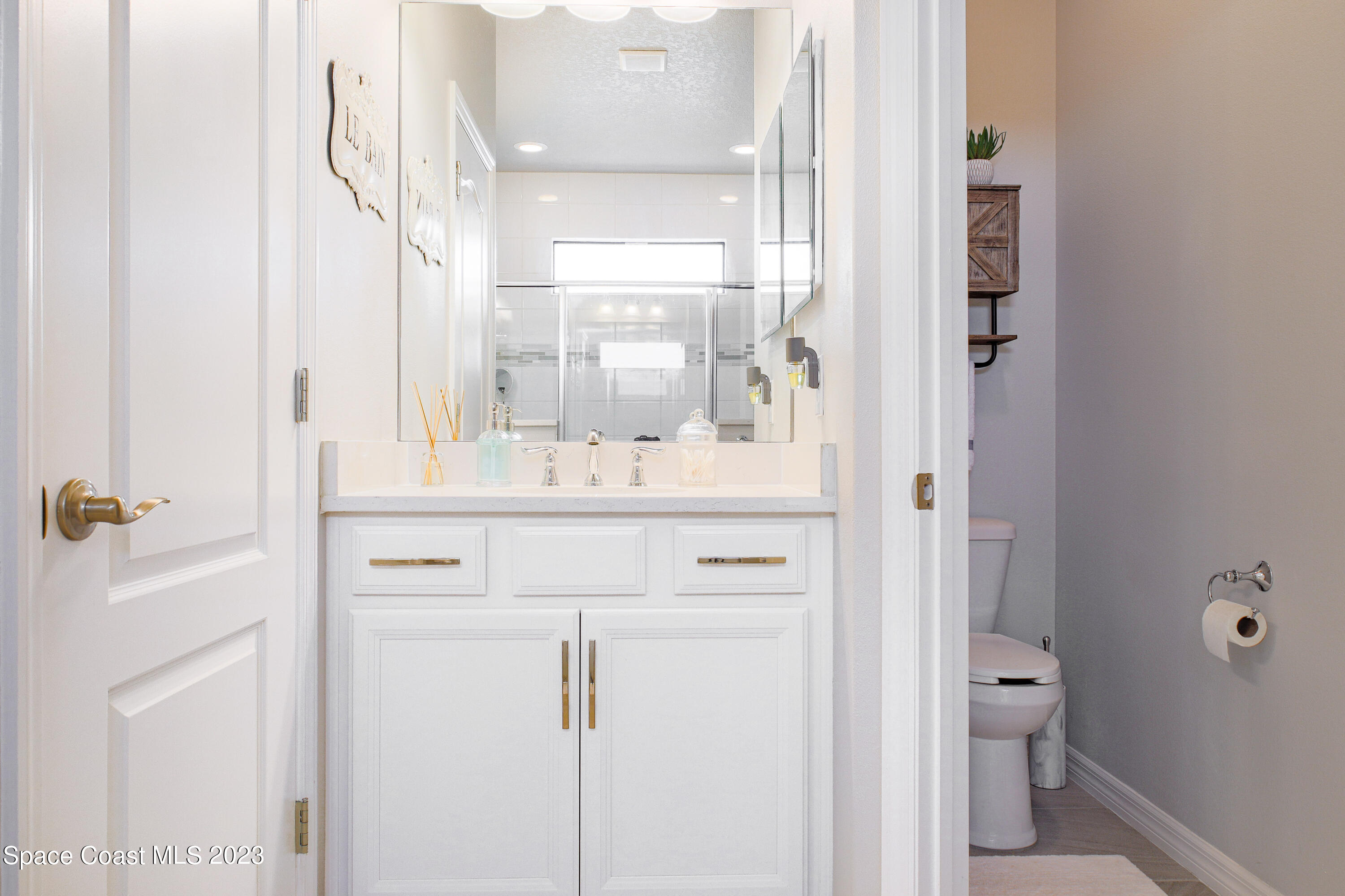 3349 Ribbon Grass Drive Melbourne, FL 32940 - Photo 15 of 45 a bathroom with a sink vanity mirror and toilet
