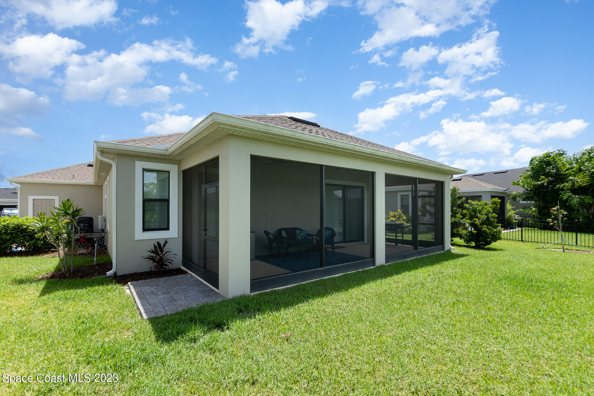 3349 Ribbon Grass Drive Melbourne, FL 32940 - Photo 26 of 45 a view of a house with brick walls and a yard with potted plants