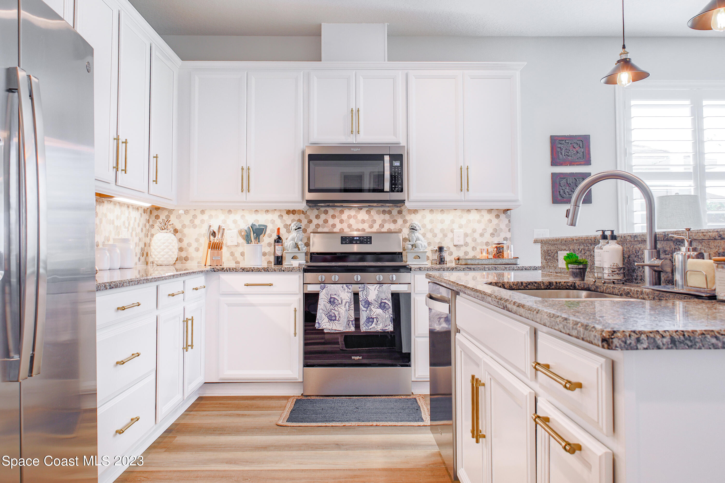 3349 Ribbon Grass Drive Melbourne, FL 32940 - Photo 3 of 45 a kitchen with granite countertop white cabinets and stainless steel appliances