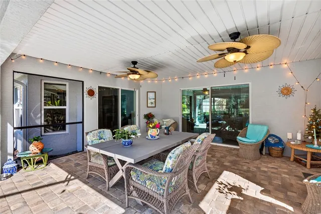 a view of swimming pool with lawn chairs and large trees