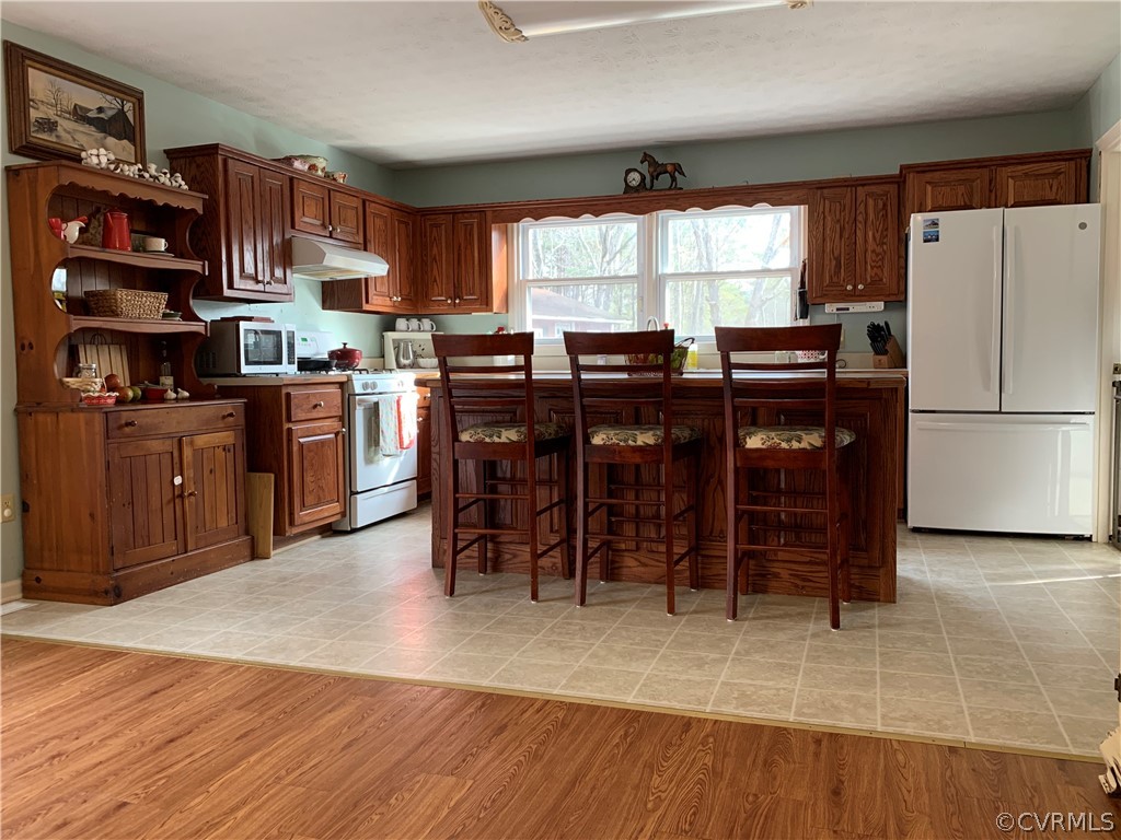 67 Mahan Road Farmville, VA 23901 - Photo 12 of 49 a kitchen with stainless steel appliances granite countertop a refrigerator a sink dishwasher a dining table and chairs with wooden floor