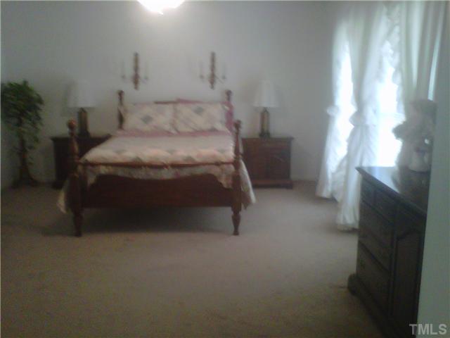 26 Chic Ennis Road Coats, NC 27521 - Photo 6 of 6 Master Bedroom Suite is very spacious. Large Walk in closet is a must see. Master Bath is highlighted with His and Her vanities, separate tub and shower.