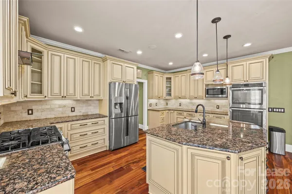 a kitchen with stainless steel appliances granite countertop a sink stove and refrigerator