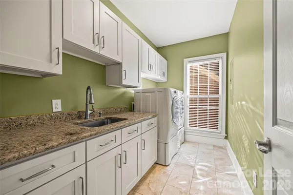 a kitchen with granite countertop a sink and a white cabinets