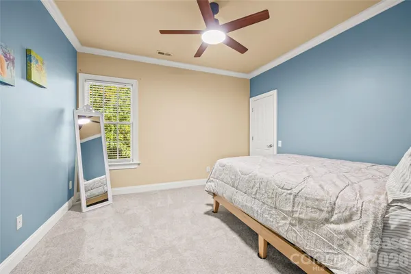 a bed room with a bed and a ceiling fan