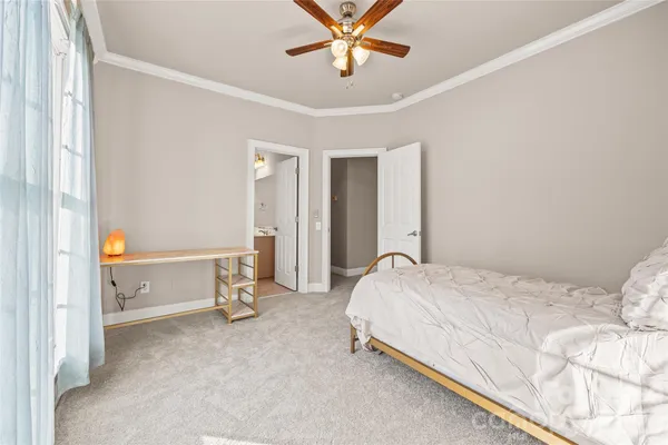 a spacious bedroom with a bed and ceiling fan