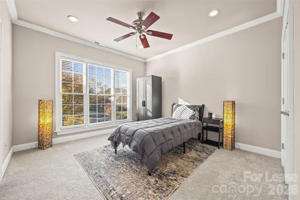 a spacious bedroom with a bed a table and a large window
