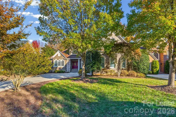 a view of a house with a big yard and large trees