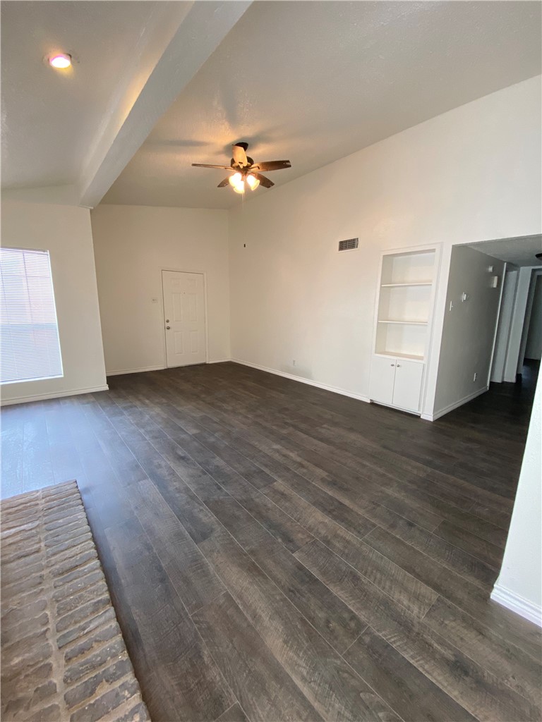 2401 Leon Street, Unit 206 Austin, TX 78705 - Photo 2 of 16 an empty room with wooden floor chandelier fan and windows