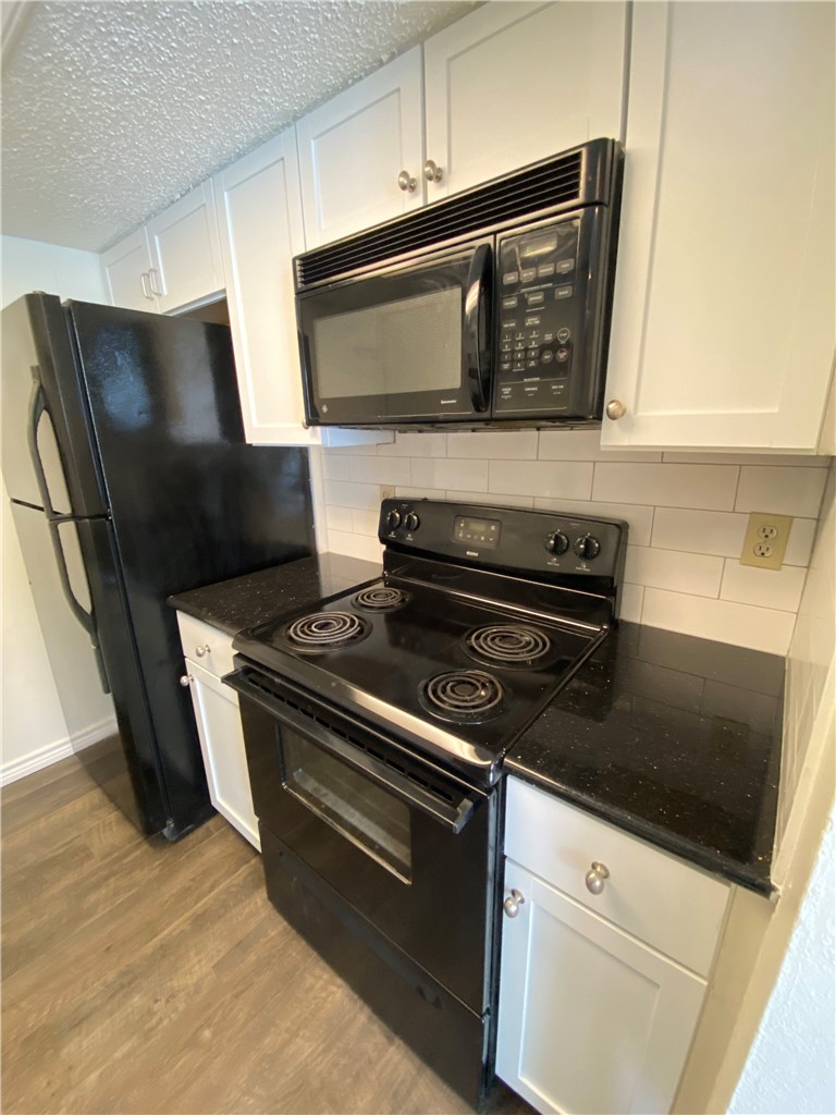 2401 Leon Street, Unit 206 Austin, TX 78705 - Photo 3 of 16 a kitchen with granite countertop a stove and a microwave