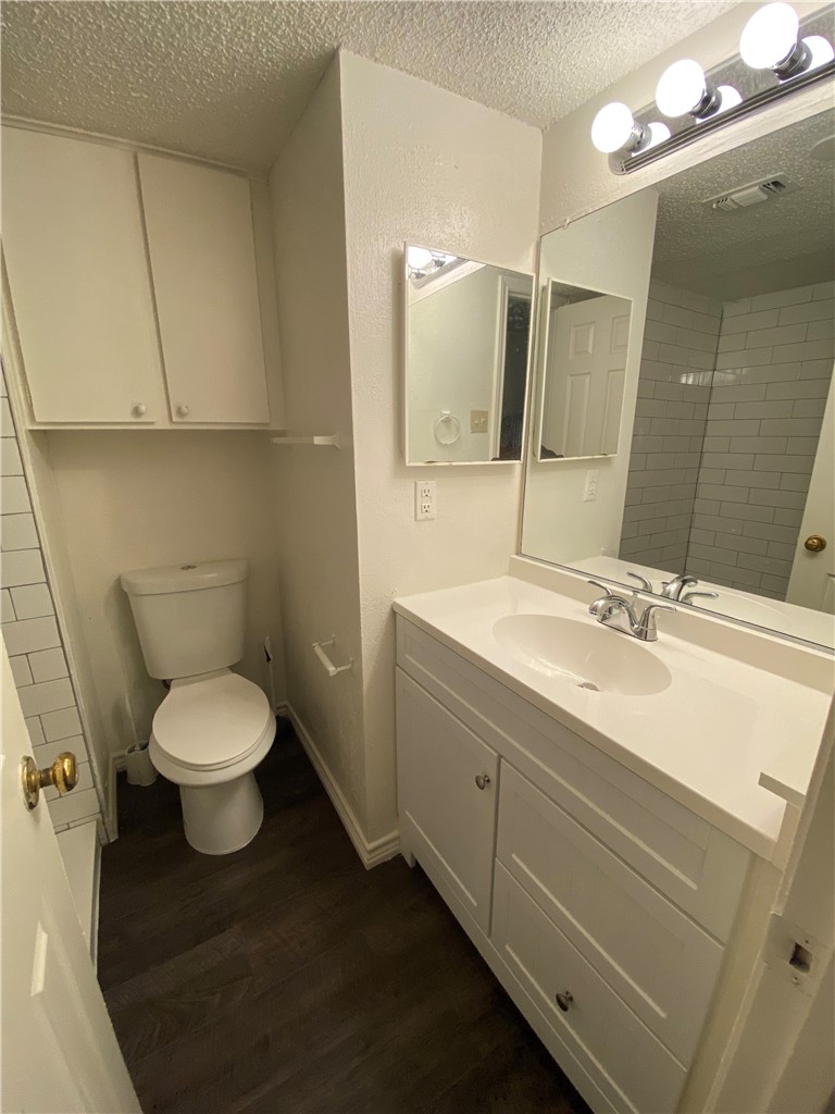 2401 Leon Street, Unit 206 Austin, TX 78705 - Photo 10 of 16 a bathroom with a toilet sink and mirror