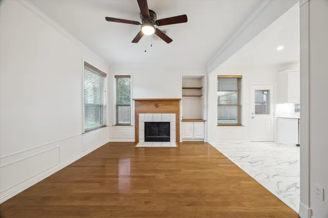 wooden floor fireplace and windows in an empty room