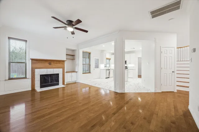 a view of a livingroom with wooden floor a fireplace and window