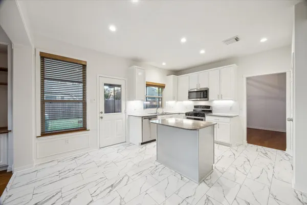 a kitchen with stainless steel appliances granite countertop a refrigerator and a sink