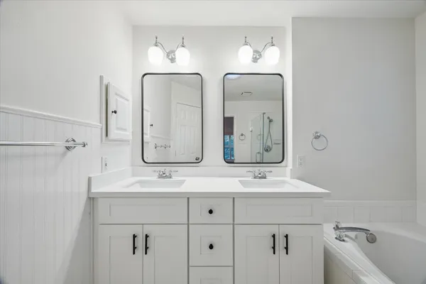 a bathroom with double vanity sinks and a mirror