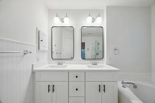 a bathroom with double vanity sinks and a mirror